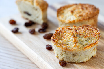 Oat, cottage cheese and raisin muffins on wooden cutting board.