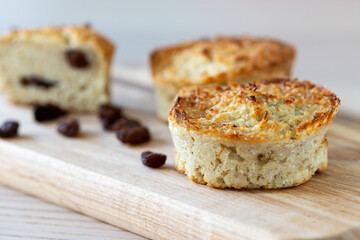 Oat, cottage cheese and raisin muffins on wooden cutting board.