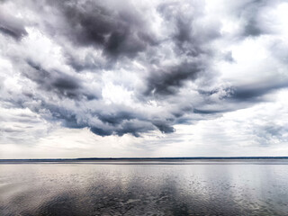 A vast expanse of water beneath a cloudy and overcast sky in the background