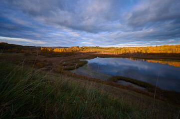 Obraz premium Beautiful Autumn Evening Landscape of a Valley with Vibrant Colors of a Lake. Autumn Evening in the Valley: Picturesque Lake and Stunning Hues of Fall Foliage