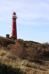 Red lighthouse on the island of Schiermonnikoog, with dunes and marram grass in the foreground
