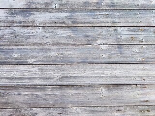 Fototapeta premium Weathered wooden planks arranged in a horizontal pattern with a rustic gray finish
