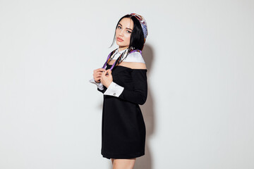 Portrait of a beautiful slender fashionable woman with a headscarf in a dress