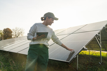 Female farmer with digital tablet on a modern farm using solar panels