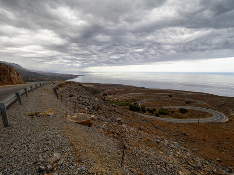 Montain road near Hora Sfakion, Crete, Grece. Libian sea in the distance on a cloudy day.