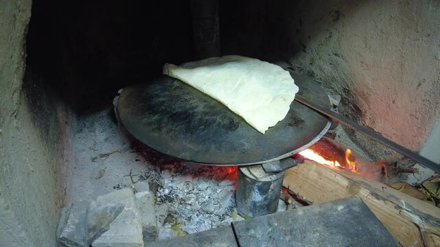 Turkish style yufka bread cooked on a baking sheet over a wood fire. 