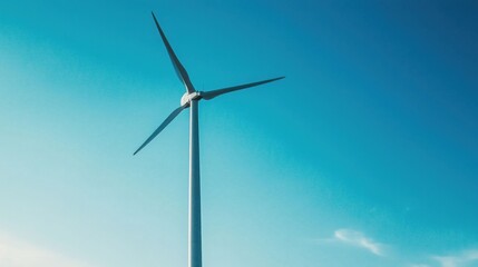 Fototapeta premium wind turbines stand majestically against a clear blue sky in a serene countryside landscape, symbolizing renewable energy and sustainability. 