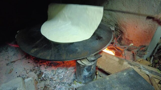 Turkish style yufka bread cooked on a baking sheet over a wood fire. 