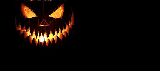 Fototapeta premium Halloween pumpkin with fangs on black background