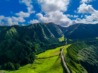 Fantastic scenic landscape with mountains and road to Lagoa de Santiago in Sao Miguel Island, Azores, Portugal. Aerial drone view of Acores islands