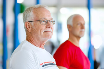 Fototapeta premium A caregiver helping a senior man with his mobility exercises in a rehab center.