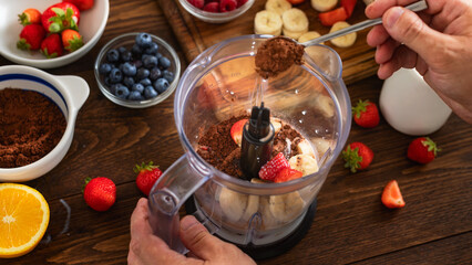 Top view of hands man in his kitchen cooking a healthy banana strawberry smoothie. Healthy lifestyle concept