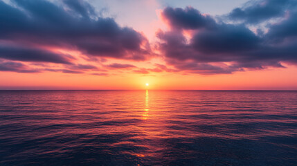 Fototapeta premium serene sunset over calm ocean waters, with vibrant colors reflecting