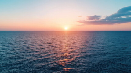 Obraz premium Sunset over calm ocean waters with warm colors reflecting on waves