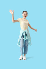 Happy young woman in headphones on blue background