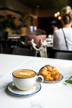 Coffee and a croissant on a marble table in a cafe  