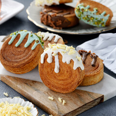 Round croissants with different filling and glaze, trendy dessert.	