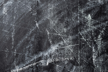A close-up of a black surface with white scratches