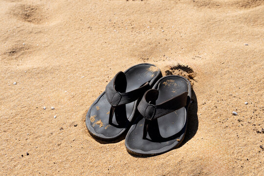Pair of flip flops in the sand on the beach 