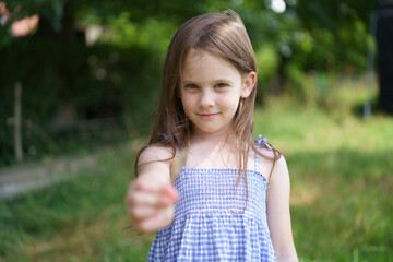 Cute girl in a sundress on the lawn close-up. Concept of children's health, travel, fun © PeterPike