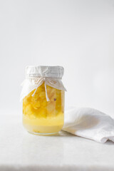 pineapple cheong in a glass jar on a white background, korean pineapple cheong in a transparent jar, pineapple in sugar syrup