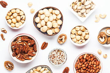 Assortment of fresh dry nuts and seeds on white background top view. healthy vegan food concept.
