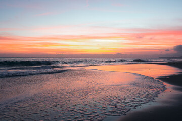 Serene moment captured on the beach, as the sky blushes with hues of pink during a captivating sunset