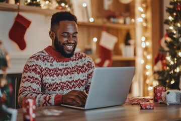 diverse man in a holiday sweater working remotely at a laptop in a home office, at online meeting, with Christmas decorations subtly displayed around