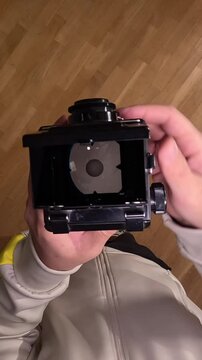 vertical video pov Photographer using vintage twin lens reflex camera 