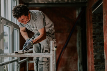 One young man is repairing a window frame.