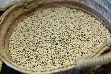 Closeup of dried bean seeds in wicker basket for sale on market ..