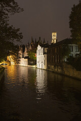 Obraz premium The Belfry of Bruges called Belfort is a medieval bell tower in Bruges, Belgium. West Flemish. West Flanders. Night picture. View from a Bruges' canal. Mirror reflection.