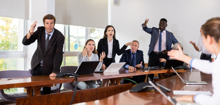 Irritated multiethnic various aged business team arguing to each other on corporate group meeting in office unable to come to a unified agreement