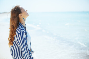 relaxed stylish woman on ocean shore enjoying tranquility