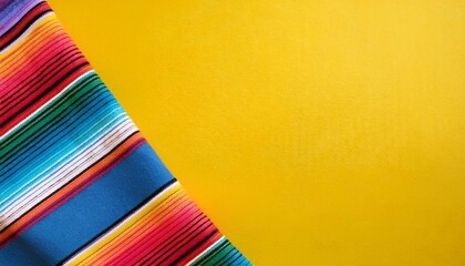 cinco de mayo holiday background made from mexican blanket stripes or poncho serape on yellow background
