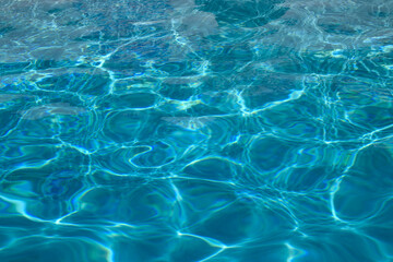Water view. Transparent water background. Blue pool water texture background. Surface of pool water with ripples.