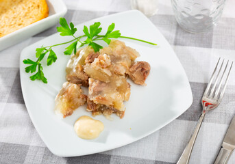 Portion of homemade jelly pork meat with sauce on plate, popular dish of russian cuisine