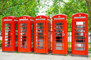 Obraz premium 5 telephone boxes lined up in red with a dilapidated appearance. 5 telephone boxes lined up in red with a dilapidated appearance near Buckingham Palace in London.