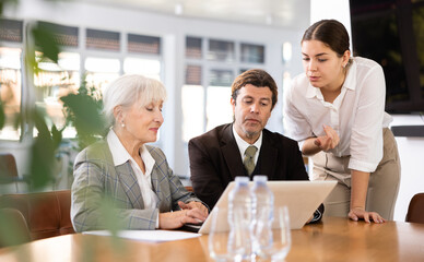 Business partners discussing documents and ideas at meeting in office