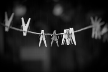  clothesline with black-and-white clothespins clipped onto it. The clothespins are in focus, while...