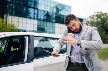 Clumsy businessman spilling coffee on his suit while exiting car