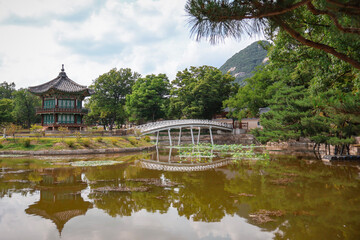 Asian garden in spring, water and bridge leading to small temple