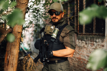 Soldier wearing tactical gear and holding assault rifle in urban environment