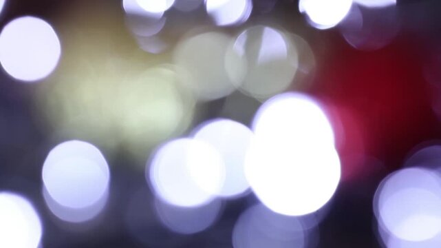 Una toma de cerca de varias luces de colores en forma de c&iacute;rculos en movimiento en la oscuridad. Desenfoque, efecto Bokeh