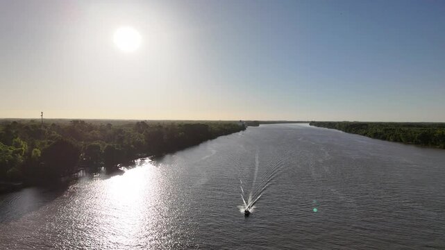 r&iacute;o paran&aacute; con &aacute;rboles en la costa y barcos navegando, atardecer