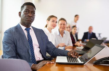 African american businessman listening speaker at business meeting