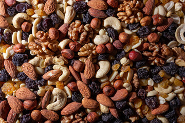 Mixed Nuts: Almonds, Walnuts, Cashews, Peanuts, Hazelnuts, Dried Prunes and Raisins. Different Nut Mix. Background from Various Nuts and Dried Fruits