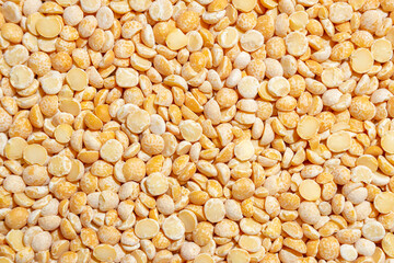 Uncooked Polished Split Peas Background. A Culinary Canvas of Dry Yellow Peas, Creating a Lively and Textured Background for Gourmet Cooking. Scattered Raw Polished Peas. Healthy Eating Ingredients