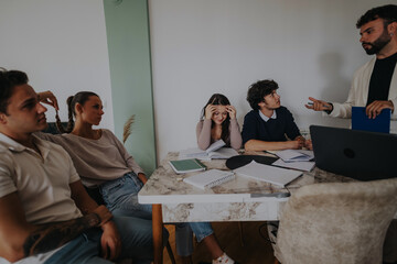 High school students work on a school project with their professor in a cozy home setting, focusing on assignments and learning collaboratively.