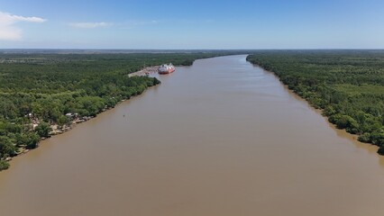 río paraná con árboles en la costa y barcos navegando, atardecer